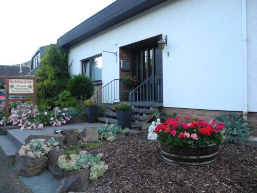 a garden with flowers in front of a building at Gästehaus Steuer in Bruttig-Fankel
