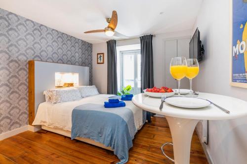 a bedroom with a bed and a table with glasses of orange juice at Cozy and perfect location Bairro Alto Chiado in Lisbon