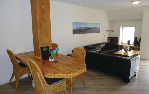 ein Wohnzimmer mit einem schwarzen Sofa und einem Holztisch in der Unterkunft Beautiful Apartment In Paesens With Kitchen in Paesens