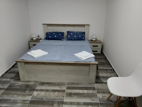 ein Schlafzimmer mit einem Bett mit blauen Kissen und einem Stuhl in der Unterkunft Take a Lake - Zabes, Virpazar in Virpazar