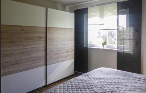 バート・シュレーマにあるAmazing Home In Aue-bad Schlema With Kitchenのベッドルーム1室(ベッド1台付)、大きな木製キャビネットが備わります。