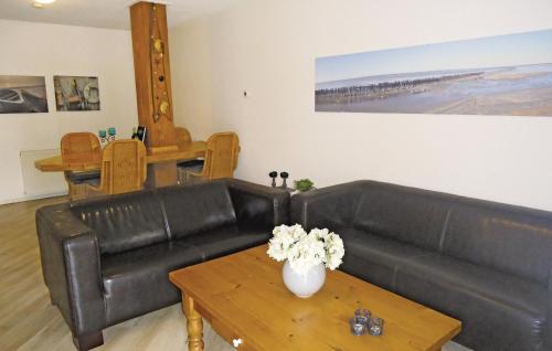 a living room with a black leather couch and a table at Pet Friendly Apartment In Paesens in Paesens