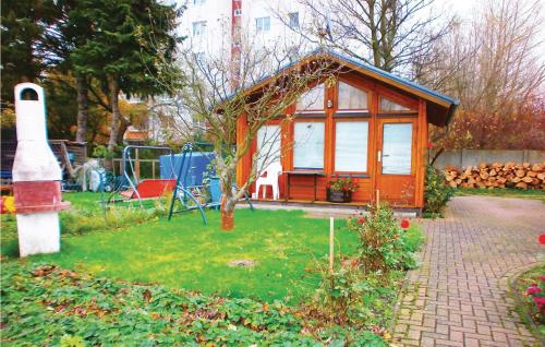 mały domek na dziedzińcu z drzewem w obiekcie Beautiful Home In Hohe Dne With Kitchen w mieście Warnemünde