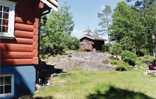a house on a hill with a church in the background at 1 Bedroom Awesome Home In Tvedestrand in Tvedestrand