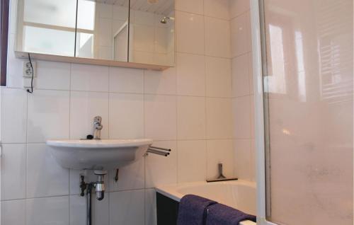 y baño blanco con lavabo y ducha. en Pet Friendly Home In Nieuwvliet-bad With Kitchen, en Nieuwvliet-Bad