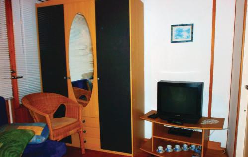 sypialnia z telewizorem i stołem z krzesłem w obiekcie Beautiful Home In Hohe Dne With Kitchen w mieście Warnemünde