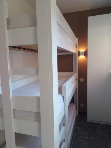 a small room with white bunk beds in it at De Zandparel in De Panne