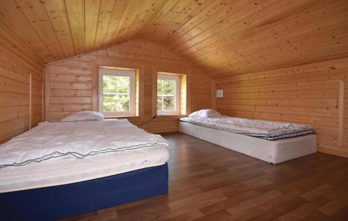 2 łóżka w drewnianym pokoju z 2 oknami w obiekcie Holiday home Anolfsbyn Mellerud w mieście Mellerud