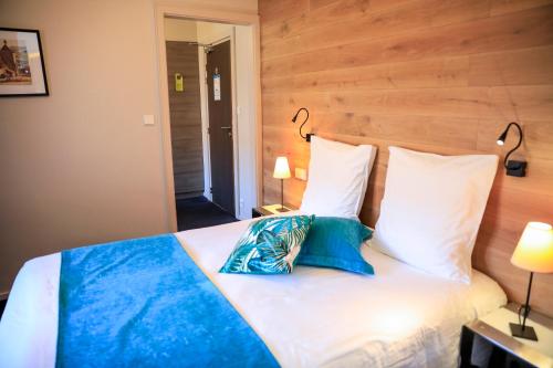 a bedroom with a bed with two pillows at Hôtel L'Auberge Alsacienne in Eguisheim