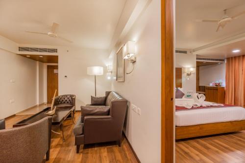 a room with a bed and a couch and a chair at Best Western Ramachandra in Visakhapatnam