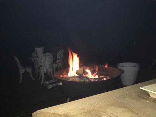 a fire in a pot next to a table at La Maison d'Arc Chambres et Tables d'Hôtes in Frasnes-lez-Anvaing