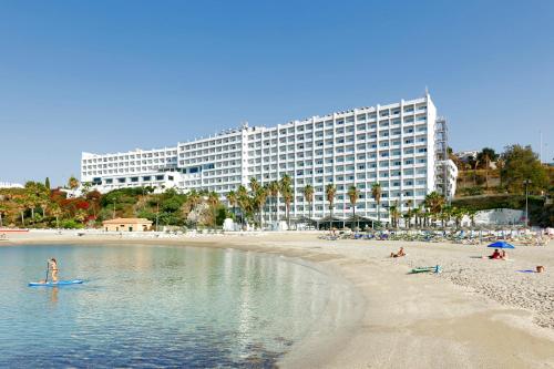 um grupo de pessoas numa praia com um grande edifício em Hotel Benalma Costa del Sol em Benalmádena