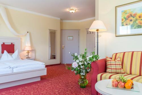Hotel Wachau في ميلك: غرفه فندقيه بسرير واريكه وطاولة