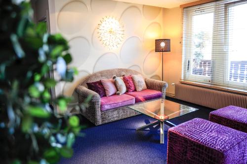 a living room with a couch and a table at Hôtel L'Auberge Alsacienne in Eguisheim