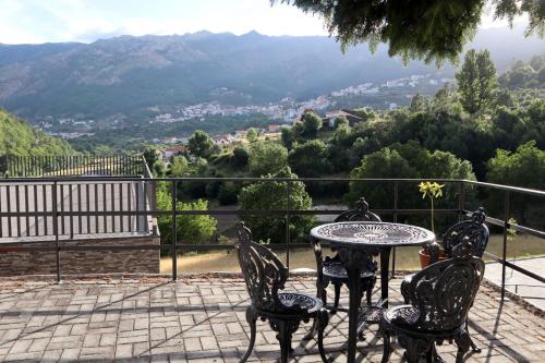 a table and chairs on a patio with a view of a mountain at Alojamento Santa Clara in Manteigas
