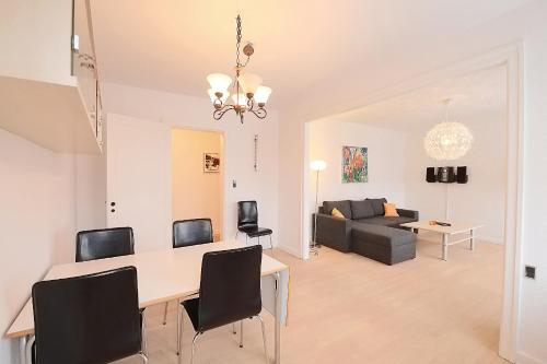 a dining room and living room with a table and chairs at Strandby Plads (ID 185) in Esbjerg
