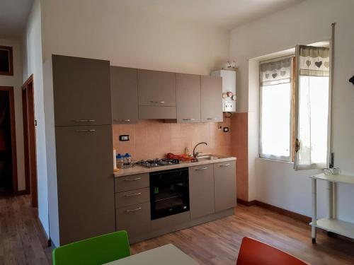 uma cozinha com armários cinzentos e um forno com placa de fogão em casa S Leonardo em Crotone
