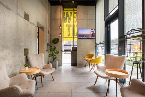 a lobby with chairs and tables in a building at Hotel New Kit in Amsterdam