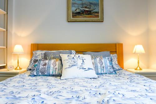 a bed with blue and white sheets and pillows at 6 Driftwood in West Bay