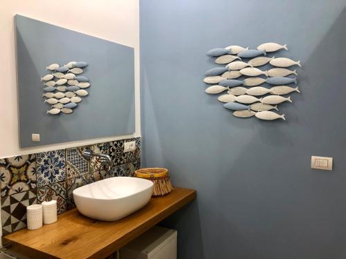 a bathroom with a sink and a wall with rocks on it at Nesh House in Siracusa