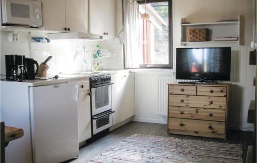 una cocina con electrodomésticos blancos y una cómoda con TV. en Awesome Studio In Transtrand With Kitchen, en Transtrand