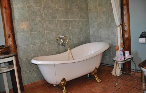 梅勒呂德的住宿－Lovely Home In Mellerud With Kitchen，带浴缸的浴室和瓷砖墙