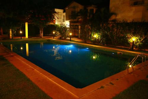 a swimming pool at night with lights at Villa Samaara14 Candolim Beach 500mts in Candolim