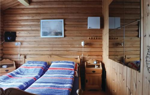 ein Schlafzimmer mit einem Bett und einer Holzwand in der Unterkunft 1 Bedroom Awesome Home In Tvedestrand in Tvedestrand