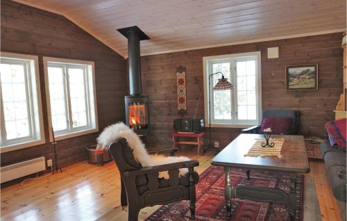 a living room with a fireplace and a table at Three-Bedroom Holiday Home In Sjusjoen in Sjusjøen