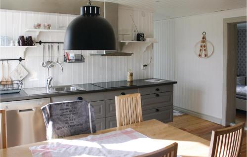 a kitchen with a sink and a table with chairs at Cozy Home In Skillingaryd With Wifi in Nydala