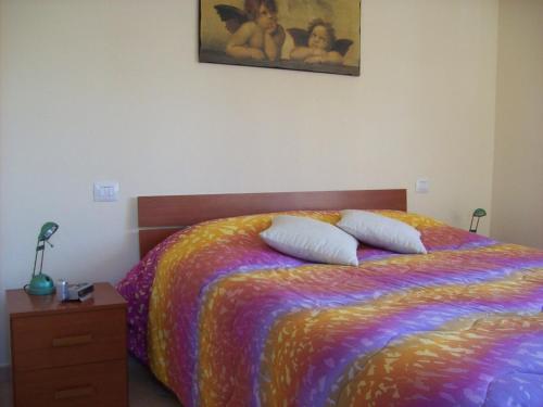a bedroom with a colorful bed with two pillows on it at Il Mirto in Viareggio