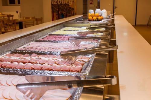 a row of trays of food on a buffet line at a&o Salzburg Hauptbahnhof in Salzburg