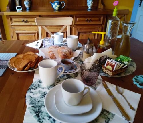 a table with cups of coffee and pastries on it at La Stanza Verde in Rossiglione