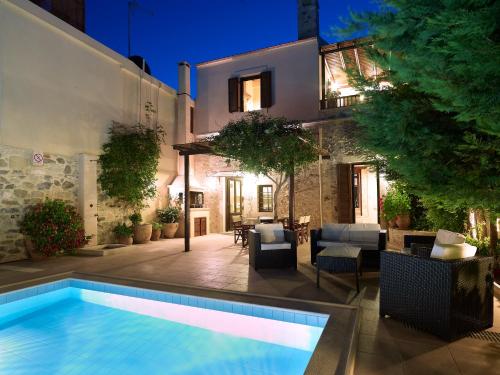 a swimming pool in front of a house at night at Agrielia Villa in Episkopi (Heraklion)