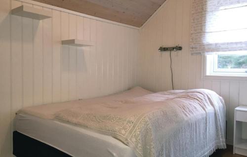a small bedroom with a bed in a room with a window at 3 Bedroom Awesome Home In senfjorden in Vollen