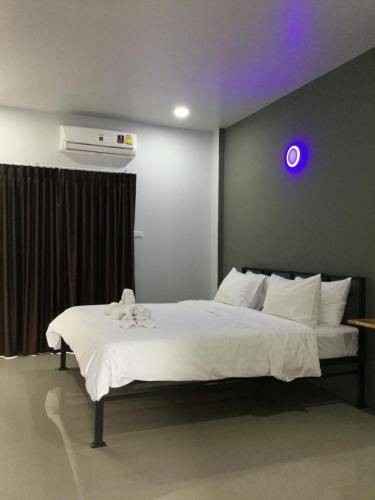 a bedroom with a white bed with a purple light at Chan Place Hotel in Nakhon Ratchasima