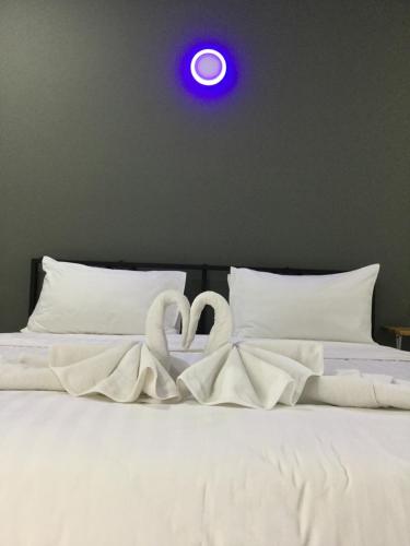 two swansrendered to look like hearts sitting on a bed at Chan Place Hotel in Nakhon Ratchasima