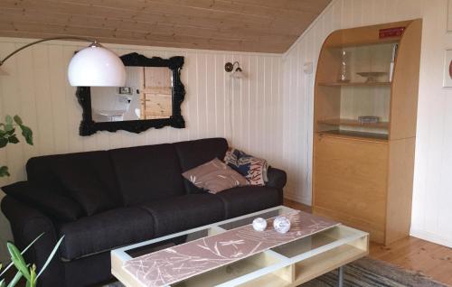 a living room with a black couch and a table at 3 Bedroom Awesome Home In senfjorden in Vollen