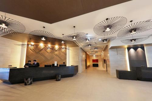 a lobby with people sitting at desks in a building at Mercure Ambassador Ulsan in Ulsan