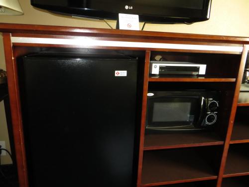 a microwave and a black refrigerator in a cabinet at Inn at Bayshore in San Mateo