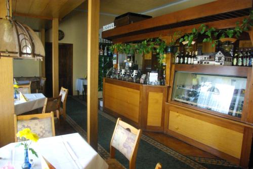 a restaurant with a bar and a table and chairs at Hotel Güldene Gabel in Unterwellenborn