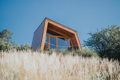 a house on top of a field of tall grass at Panorama Glamping Visole in Slovenska Bistrica