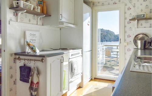 a kitchen with a washer and dryer and a balcony at Three-Bedroom Holiday Home In Brastad in Brastad