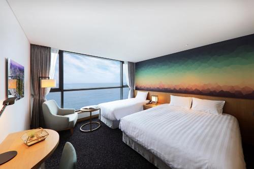 a hotel room with two beds and a desk at Mercure Ambassador Ulsan in Ulsan