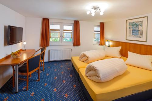a hotel room with two beds and a desk at Historische Residenz Lindeneck in Güttingen