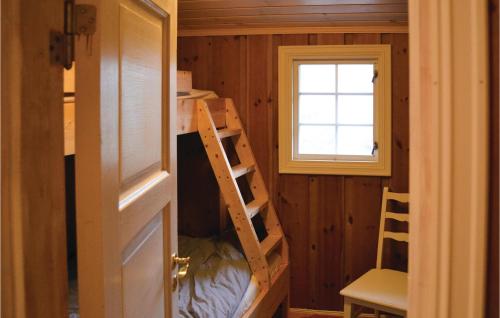 SjusjøenにあるBeautiful Home In Sjusjen With 3 Bedroomsの二段ベッド1組、はしご、窓が備わる客室です。