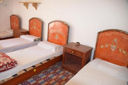 a room with three bunk beds and a table at Sheikh Mousa Bedouin Camp in Saint Catherine
