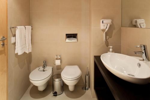 a bathroom with a toilet and a sink at The Lisbonaire Apartments in Lisbon