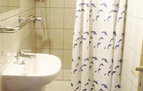 a bathroom with a shower curtain with a toilet and a sink at Gorgeous Apartment In Noertrange With Wifi in Noertrange