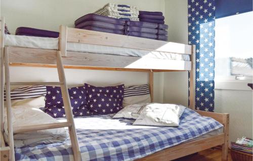 a bedroom with two bunk beds with a blue and white checkered mattress at Three-Bedroom Holiday Home In Brastad in Brastad